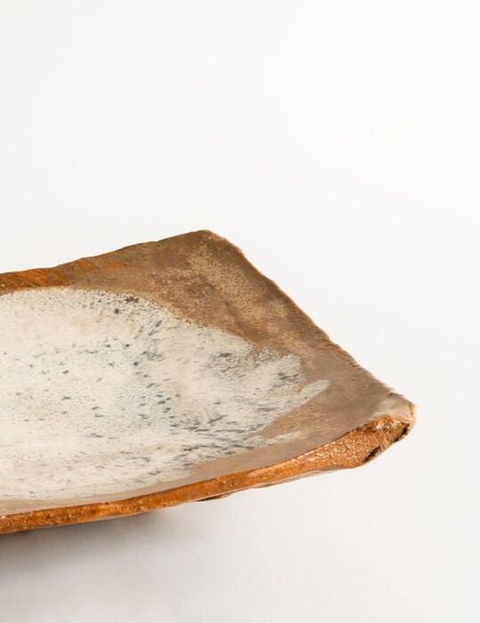 Foto di dettaglio del piatto da portata Throw tray realizzato da Cono9. L'argilla è lavorata con martello su stampo convesso. Lo smalto auto-prodotto è di tipo Nuka. Il manufatto è cotto in cono 6 in ossidazione. Il ceramista e artigiano che ha realizzato l'opera è Maurizio Gualdi. 