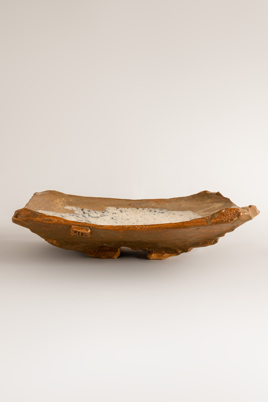 Foto di dettaglio del piatto da portata Throw tray realizzato da Cono9. L'argilla è lavorata con martello su stampo convesso. Lo smalto auto-prodotto è di tipo Nuka. Il manufatto è cotto in cono 6 in ossidazione. Il ceramista e artigiano che ha realizzato l'opera è Maurizio Gualdi. 