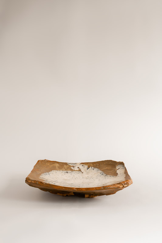 Foto di dettaglio del piatto da portata Throw tray realizzato da Cono9. L'argilla è lavorata con martello su stampo convesso. Lo smalto auto-prodotto è di tipo Nuka. Il manufatto è cotto in cono 6 in ossidazione. Il ceramista e artigiano che ha realizzato l'opera è Maurizio Gualdi. 
